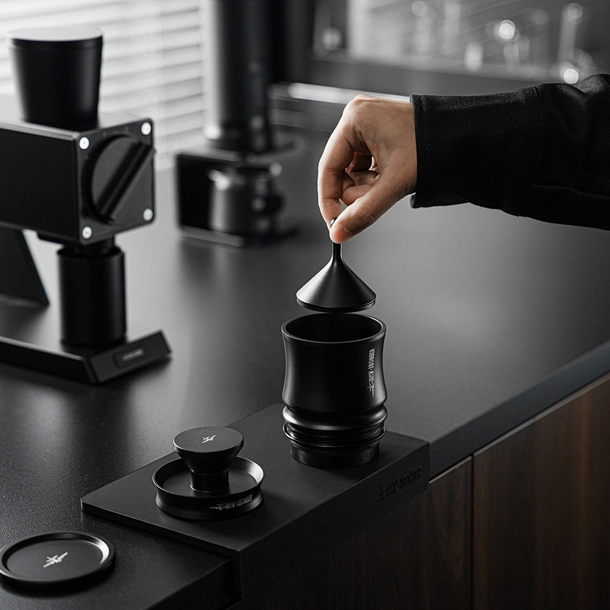 Embudo agitador MHW-3BOMBER Shaker Funnel 58mm negro al retirarlo del portafiltro con la molienda distribuida